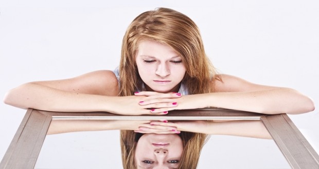 young woman looking into a mirror